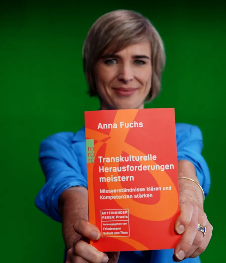 Anna Fuchs holding her book Transkulturelle Herausforderungen meistern